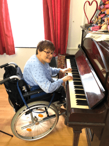 Resident learning to play the piano at Park road care home