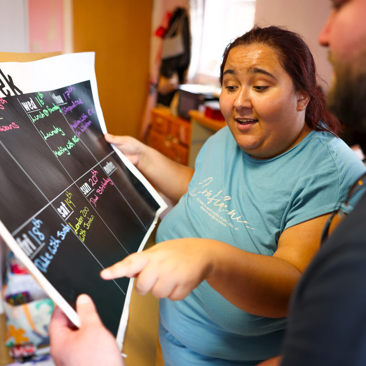 Photo of a support worker and young person working on a visual planner Photo of a support worker and young person working on a visual planner